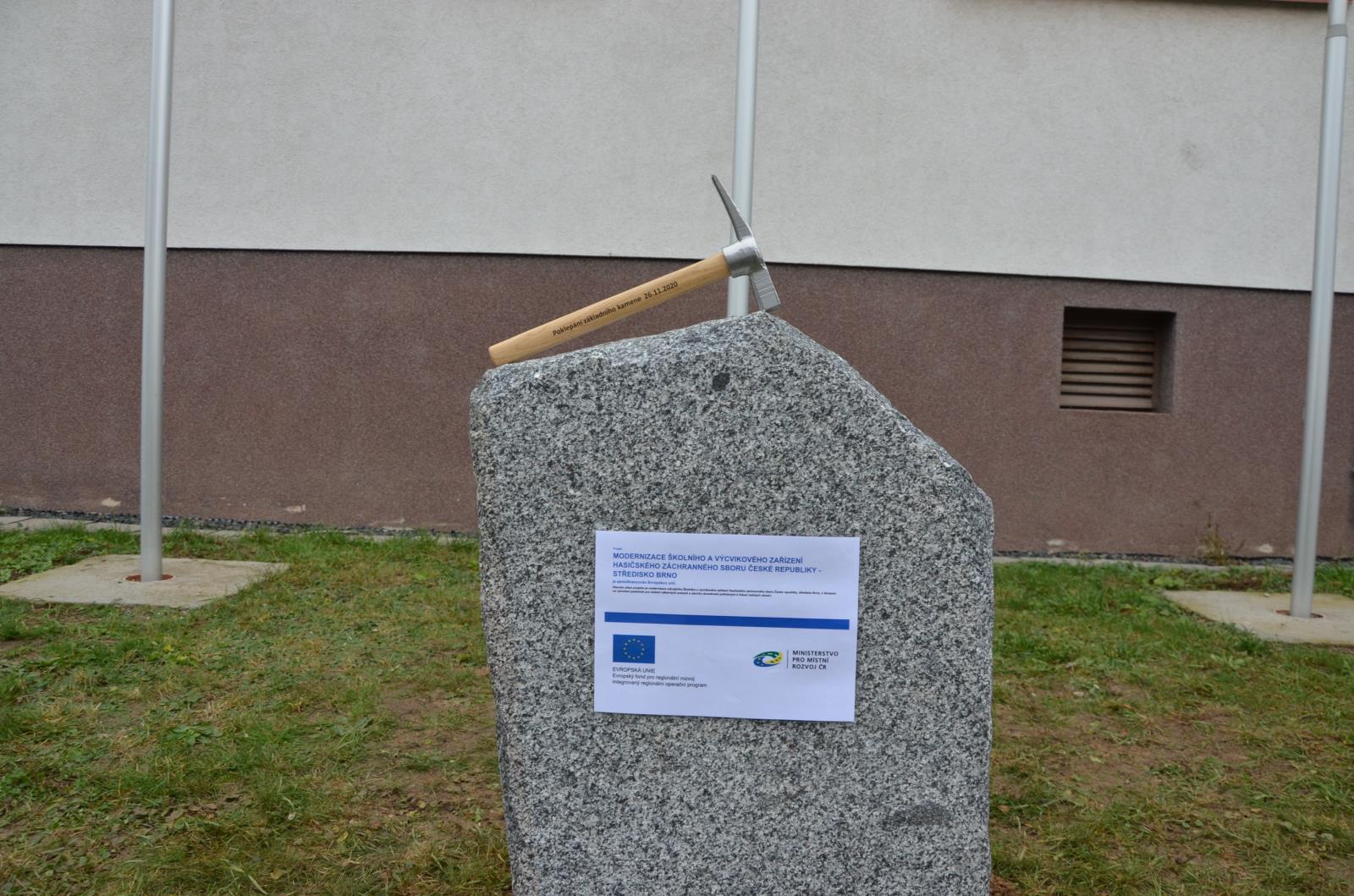 Pohled na základní kamen s kladívkem a cedulí upozorňující na projekt EU.JPG