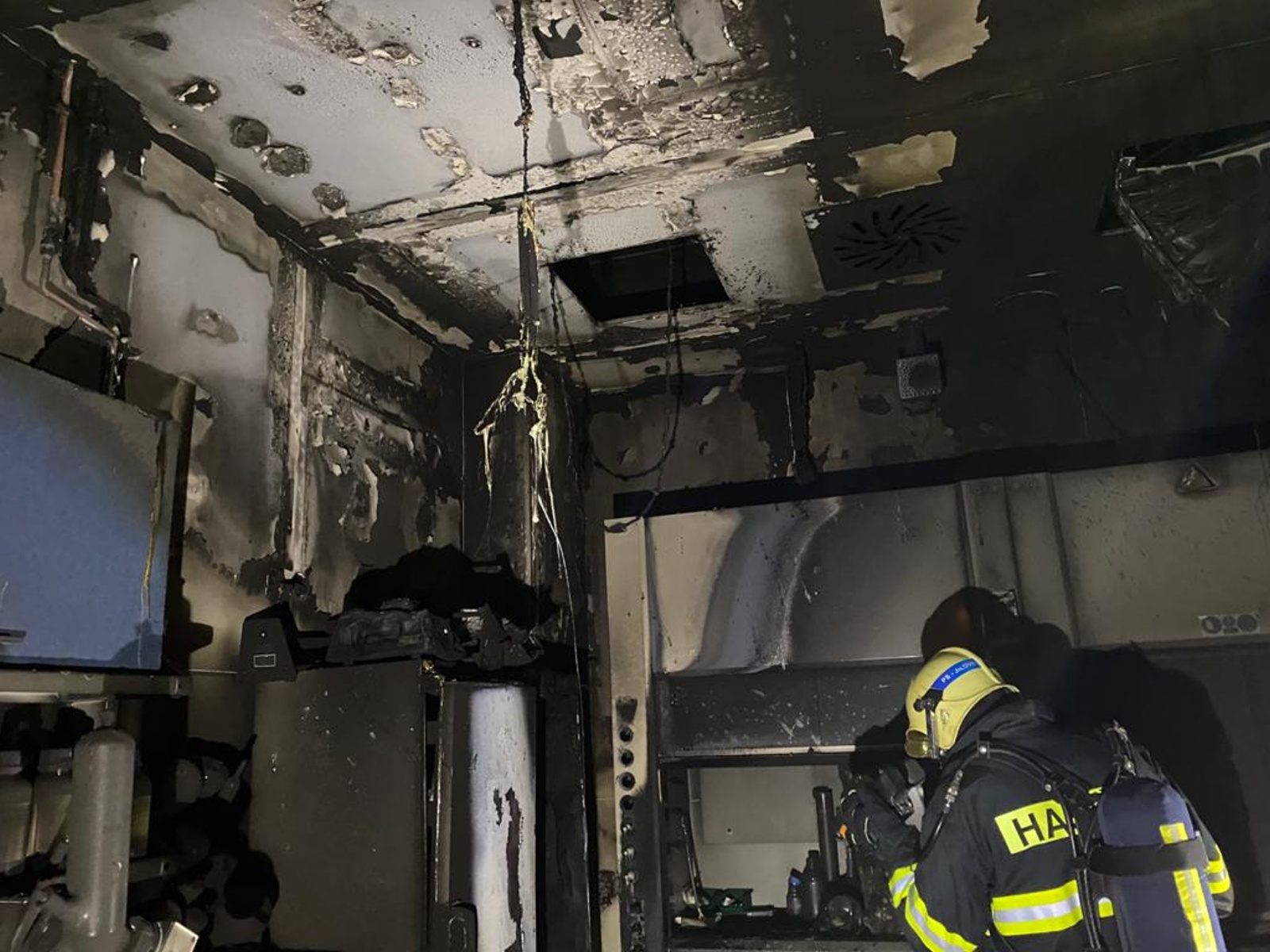 SČK_požár ve výzkumném ústavu ve Vestci_hasič prohlíží místnost, kde vznikl požár.jpg
