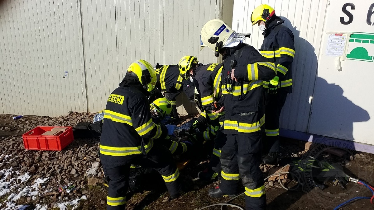 PAK_pohled na hasiče zachraňují muže, který uvízl mezi mostní konstrukcí a unimobuňkou.jpg