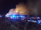 KHK_hořely historické vagony v Jaroměři_noční snímek_pohled na zasahující hasičskou techniku_v pozadí stoupá dým z hořících souprav.png