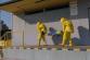 MSK_Taktické cvičení složek IZS_Únik nebezpečného plynu z areálu ostravské firmy_2 hasiči ve žlutých ochranných oblecích vynášejí z budovy na nosítkách zraněnou osobu