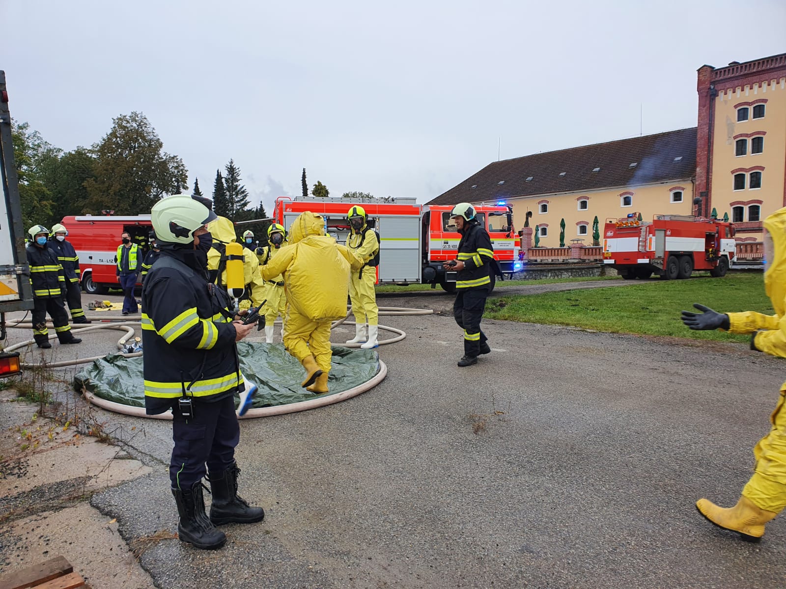 JČK_Úniku čpavk v Třeboni_jednotka hasičů, část v zásahových oblecích, část v ochranných se připravuje zasáhnout v objektu, kde unikl čpavek.jpg