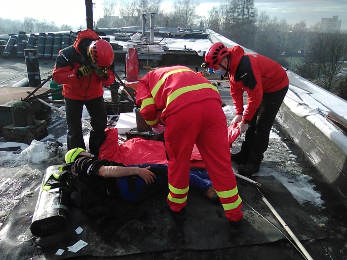 MSK_záchrana zraněného muže ze střechy panelového domu v Ostravě_hasiči a záchranáři na střeše poskytují muži ošetření.jpg