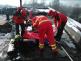 MSK_záchrana zraněného muže ze střechy panelového domu v Ostravě_hasiči a záchranáři na střeše poskytují muži ošetření