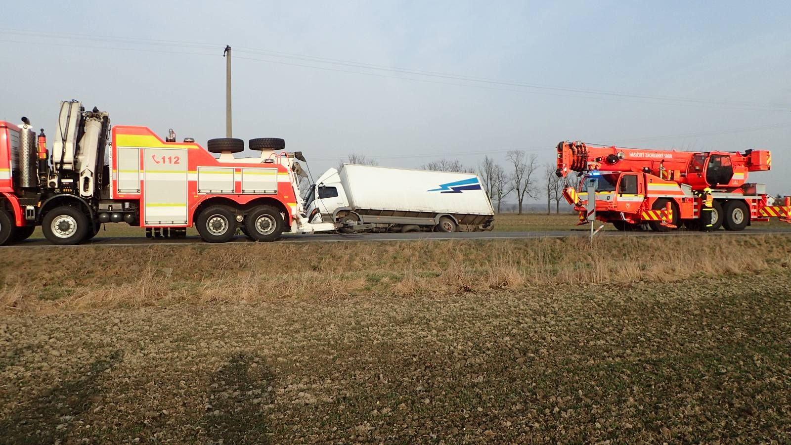 Jeřáb a Bison vytahují v Dolním Benešově havarovaný nákladní automobil.jpg