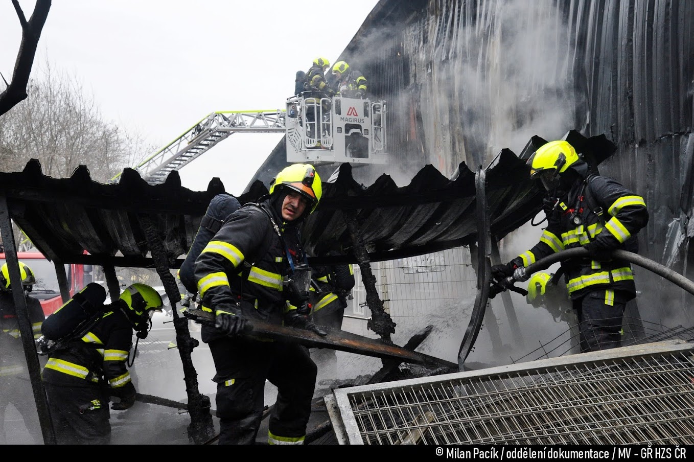 PHA_požár hangáru na letišti na Točné_hasiči zasahájí z plošiny i na zemi v sutinách.jpg