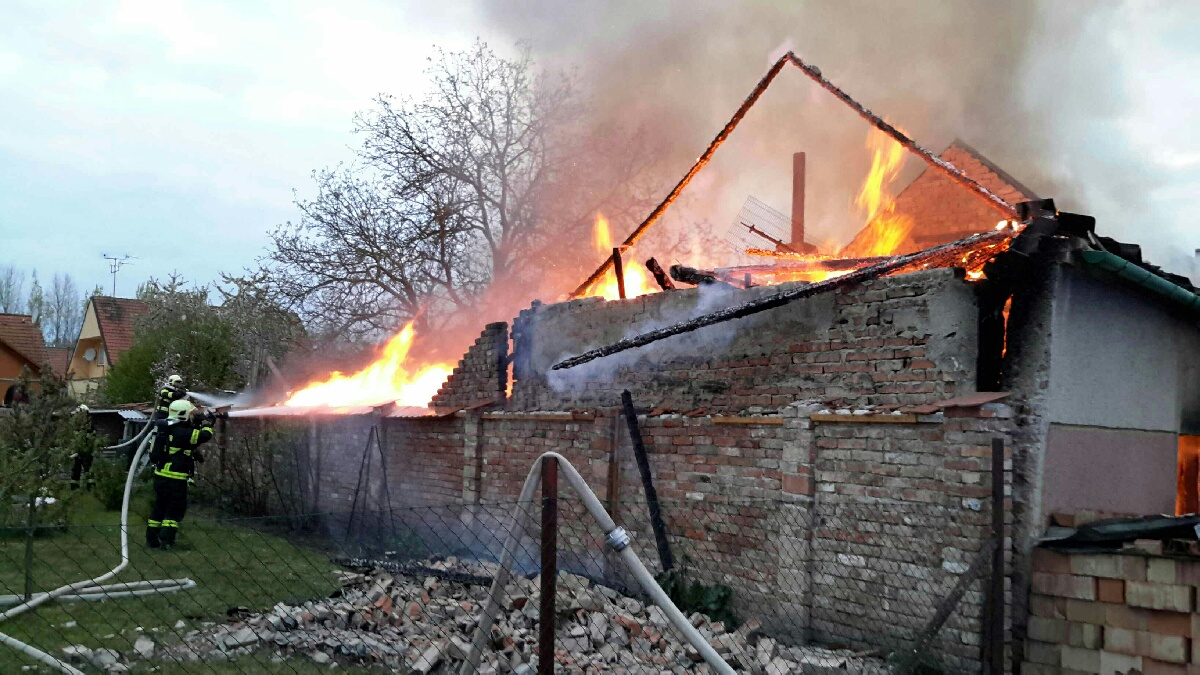 JMK_požár RD v obci Novosedly na Břeclavsku_pohled na zasahující hasiče a na hořící dům a dvůr.jpg