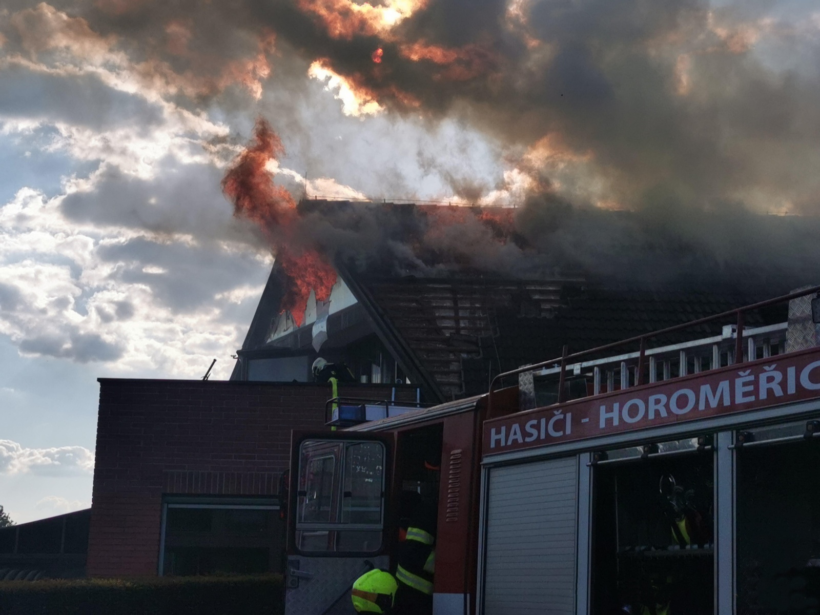 SČK_Požár RD v Horoměřicích_pohled na hořící objekt a hasiče chystající se k zásahu.jpg