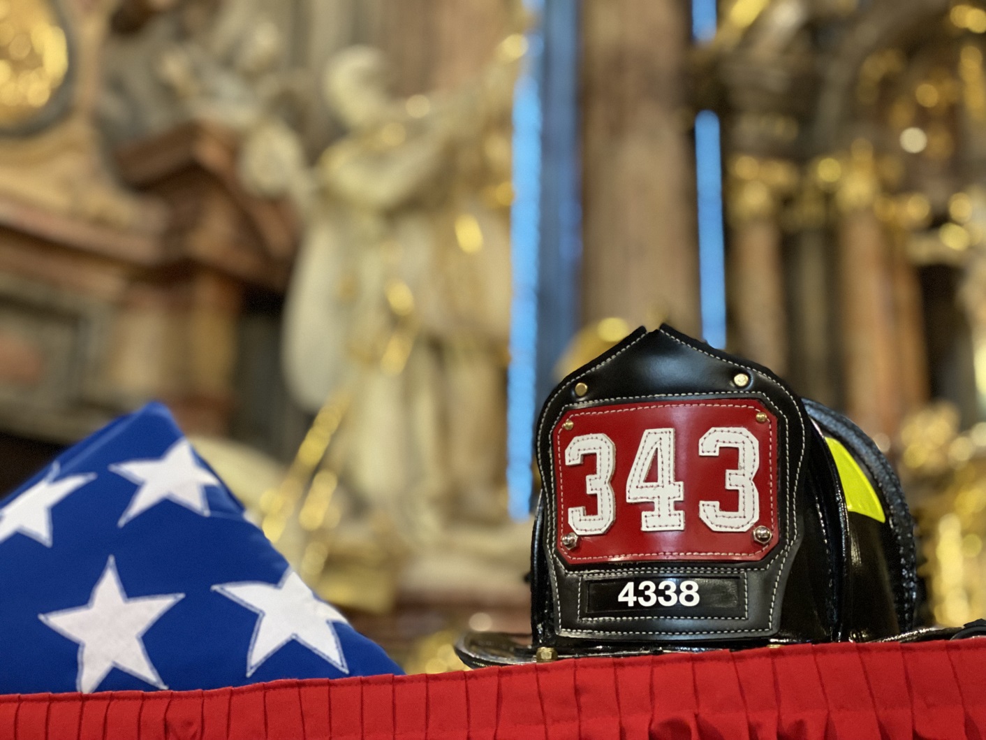 12_Pietní akt v chrámu sv. Mikuláše, pohled na přilbu amerického hasiče a americkou vlajku před oltářem (2).jpg