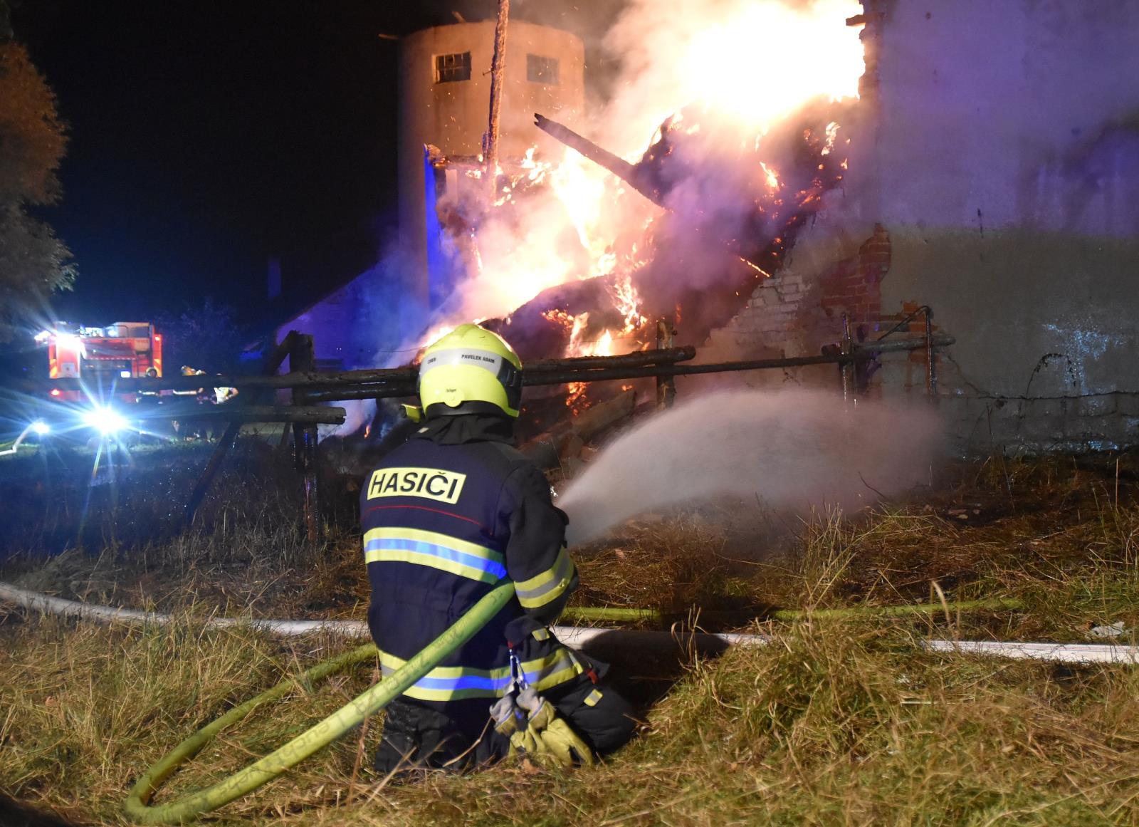 KVK_Požár seníku v Loužku na Chebsku-pohled na zasahujícího hasiče a hořící objekt.jpg