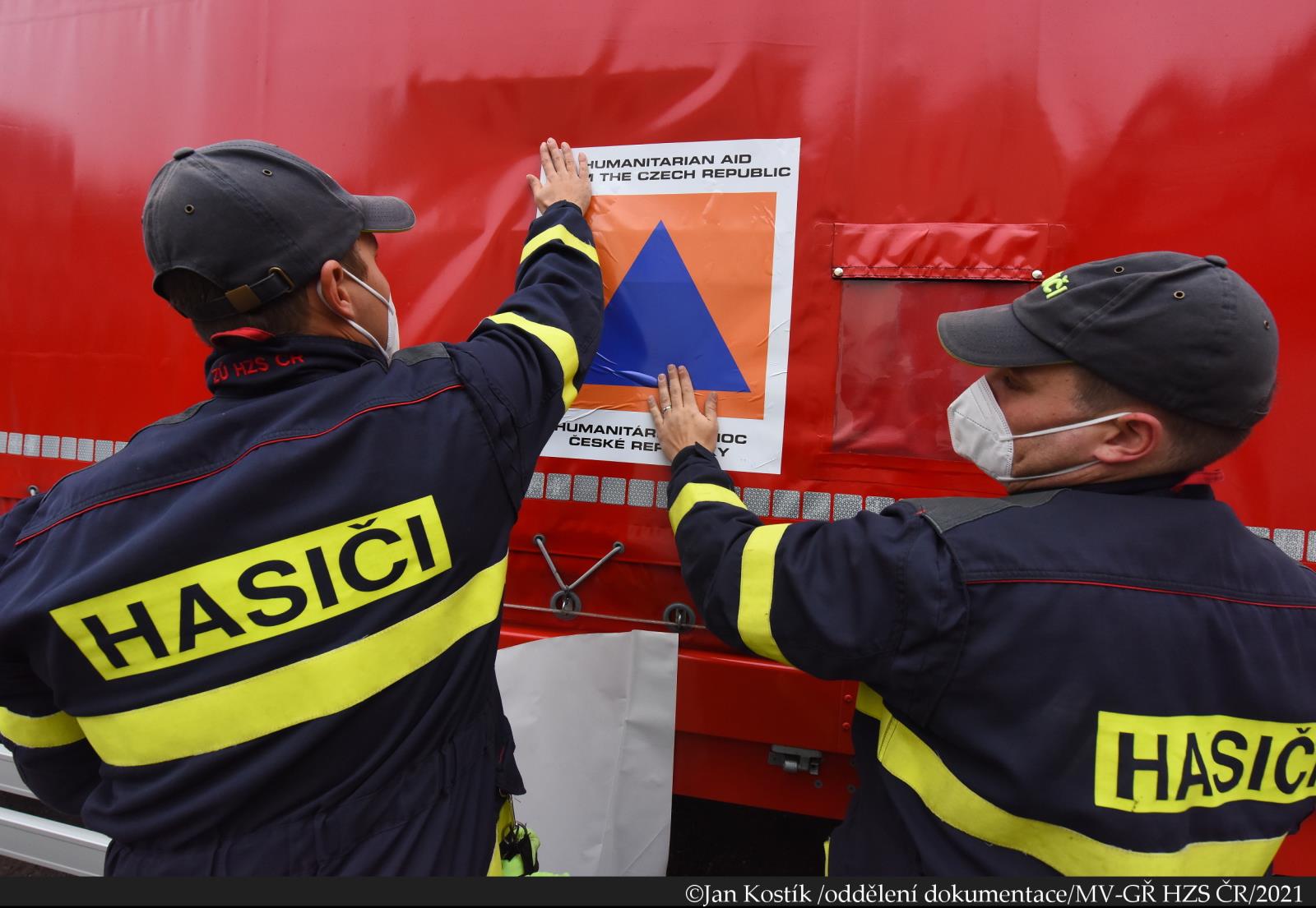 HP Lotyšsko_hasiči označují vůz znakem humanitární pomoci (2).JPG