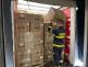 Příslušník ZÚ HZS ČR nakládá krabice s respirátory na korbu nákladního vozu 