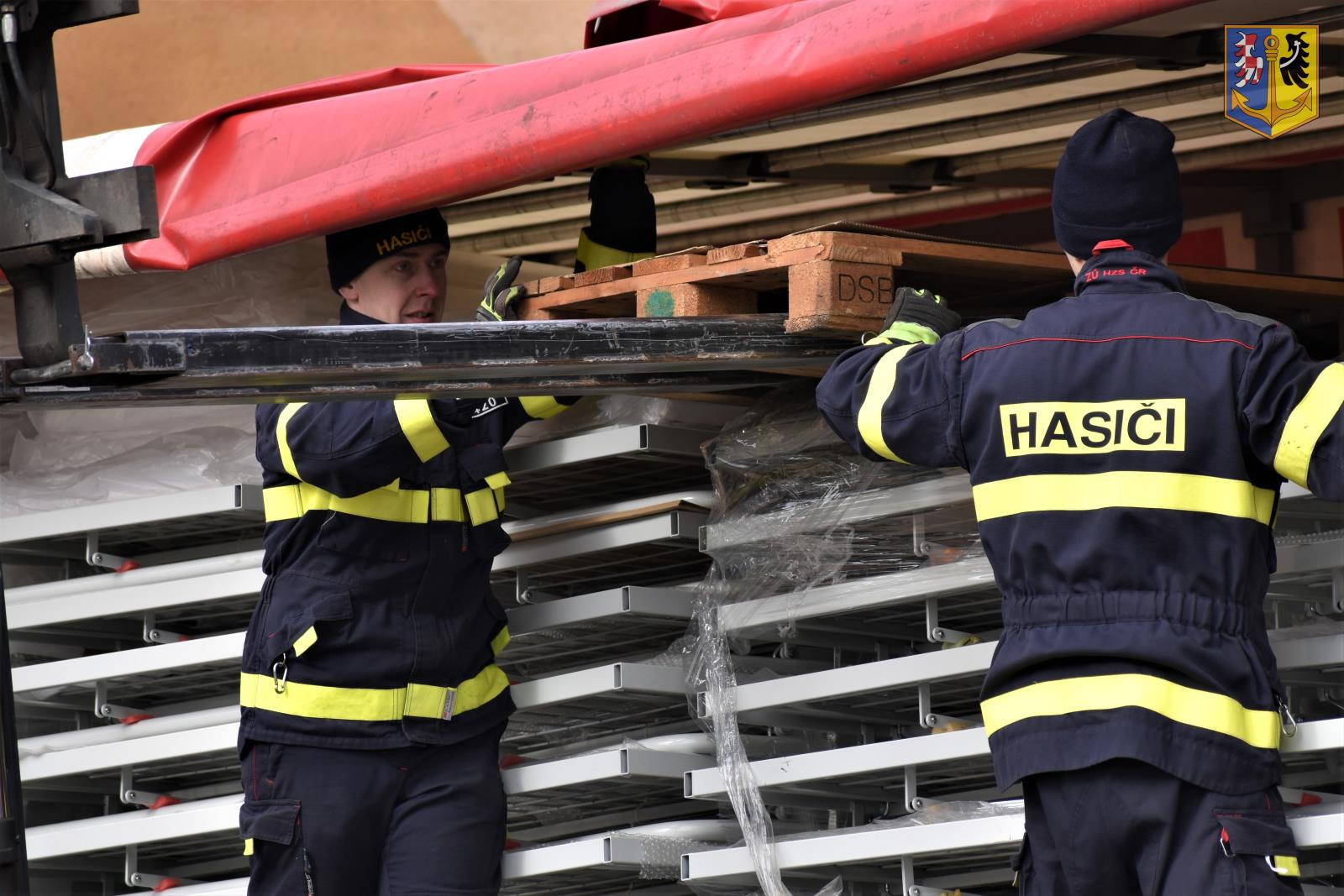 Příslušníci Záchranného útvaru HZS ČR nakládají humanitární pomoc na techniku, která ji přepraví na Ukrajinu