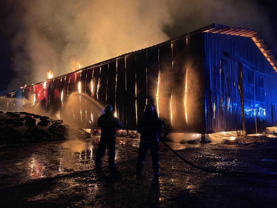 KHK_požár skladovací haly v Dolním Lánově_pohled na 2 zasahující hasičea halu v plamenech.jpg