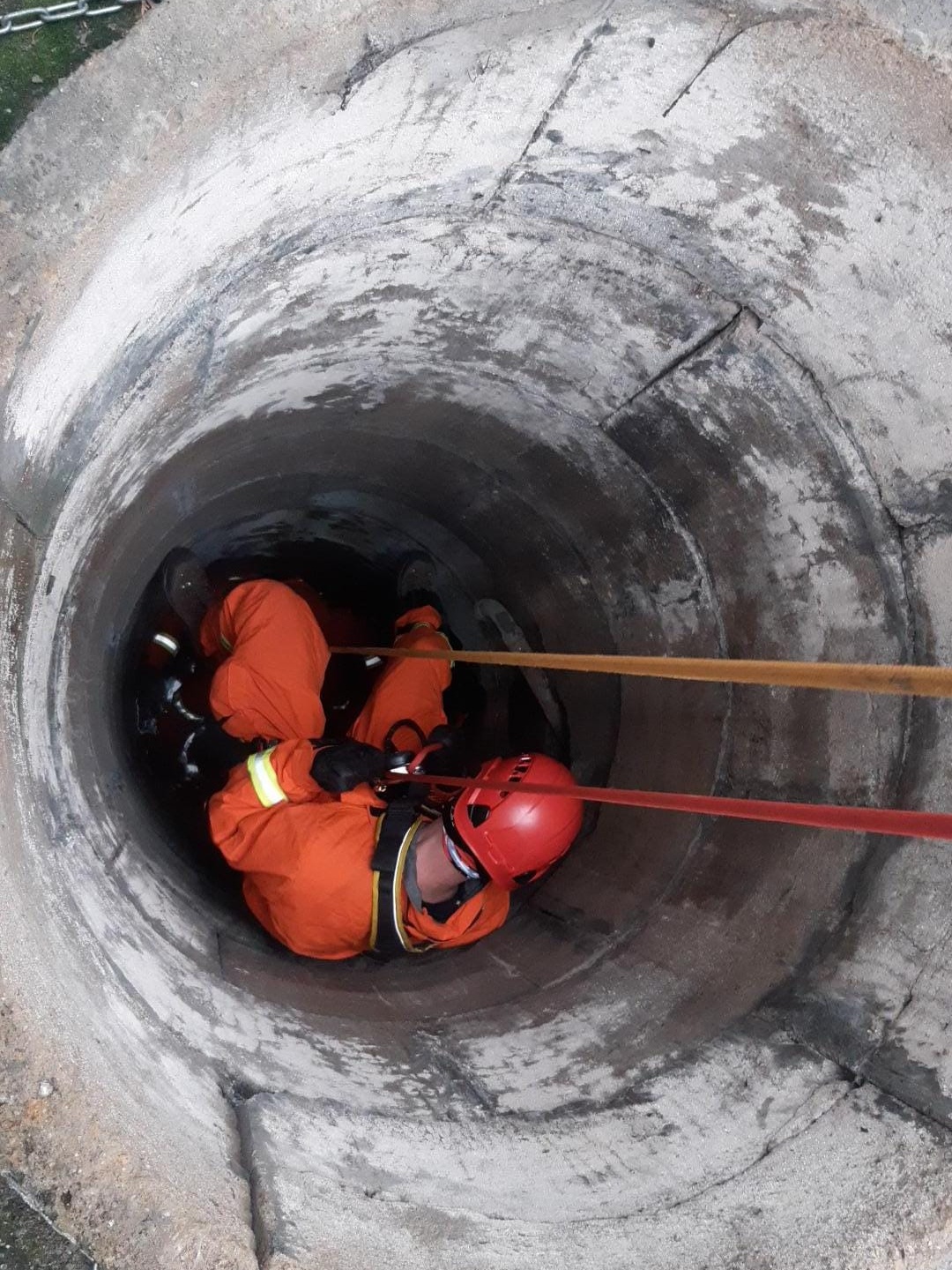 SČK_Záchrana osoby z hloubky_hasič se spouští za pomocí lana do studny.jpg