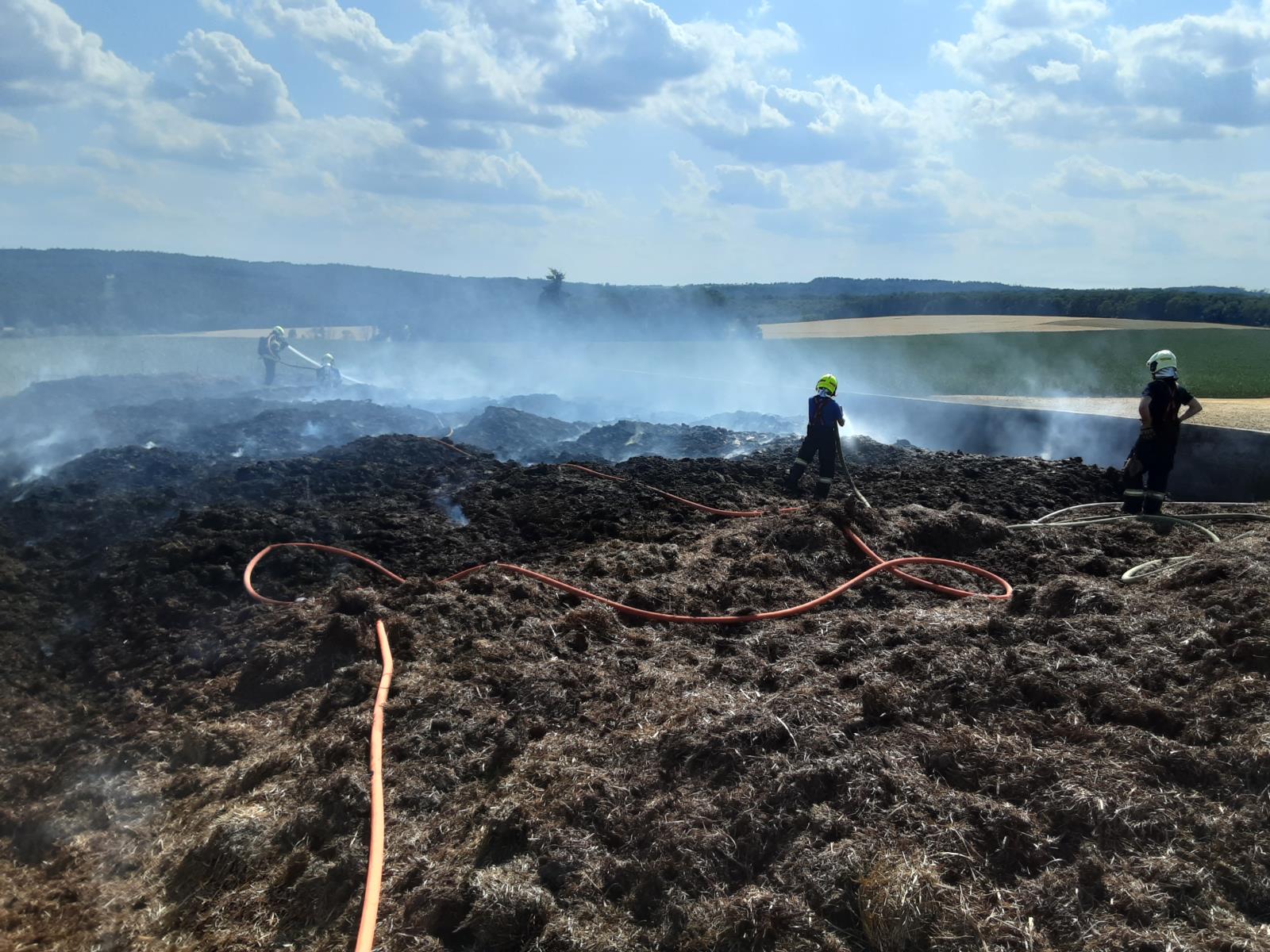 Náročný požár prostor pro uskladnění siláže - na pomoc dorazila zemědělská technika, zásobování vodou řešeno z přehrady Vilémov.