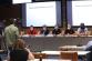 Tisková konference - pohled na předsednický stůl se členy ÚKŠ a novináři v popředí