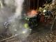 ZLK_DN s tragickými následky_2 hasiči hasí hořící osobní automobil, který spadl ze srázu do lesa