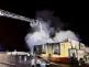 PHA_Požár autoservisu v Praze 15_hasiči při práci na plošině i na zemi