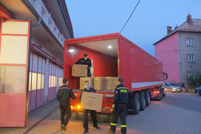 MSK_hasiči přivezli do Ostravy respirátory pro učitele_3 hasiči vykládají z kamionu krabice s respirátory.jpg