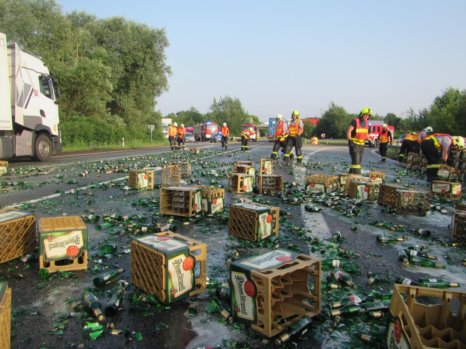ZLK_Hasiči odklízejí ze silnice rozbité pivní lahve, které se vysypaly z kamionu.jpg