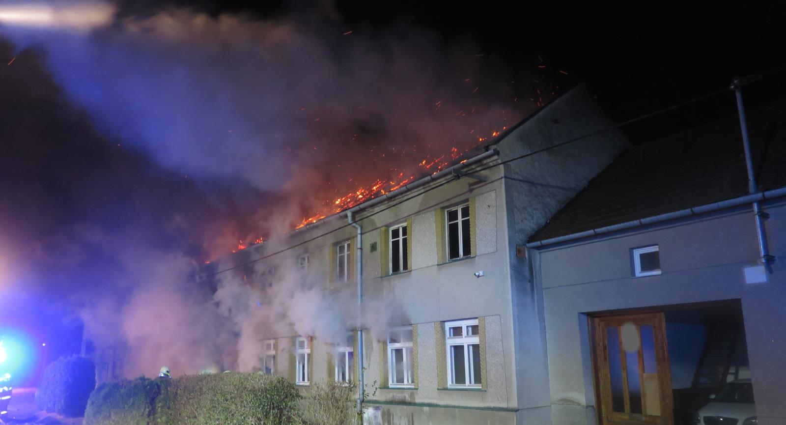 OLK_Požár rodinného domu a auta v Držovicích_hořící objekt a proud vody dopadající na plameny.jpg