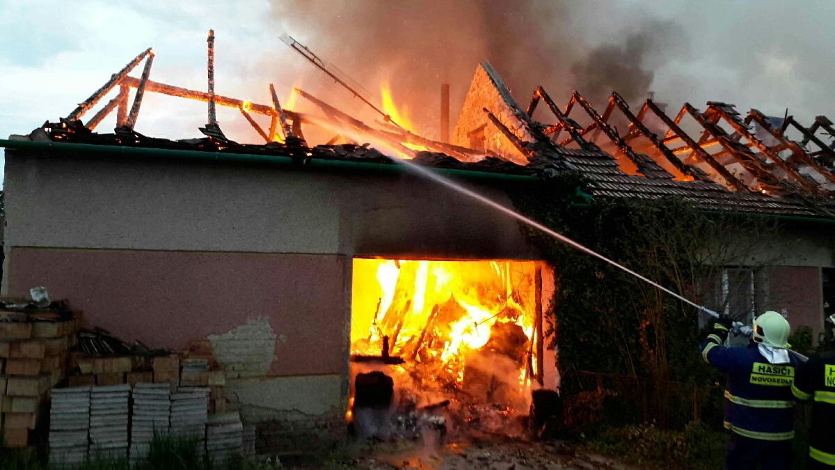 JMK_požár RD v obci Novosedly na Břeclavsku_pohled na zasahující hasiče a na hořící dům.jpg
