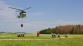 JMK_výcvik - plnění hasícího vaku a letadla_vrtulník přilétá s prázdným vakem na pole, kde čeká 7 hasičů s hadicemi, aby ho naplnili