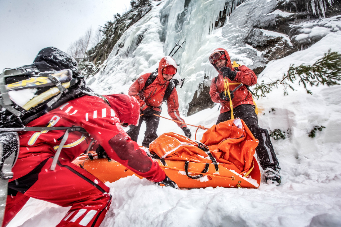 KHK_hasiči lezci při kurzu bezpečného pohybu a záchrany osob v zimním nepřístupném terénu v Krkonoších_3 hasiči vytahují nosítka po zasněženém svahu nahoru.jpg