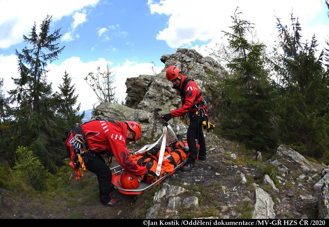 PHA_výcvik leteckých záchranářů_2 záchranáři v horách stabilizují na nosítkách zraněného figuranta.JPG