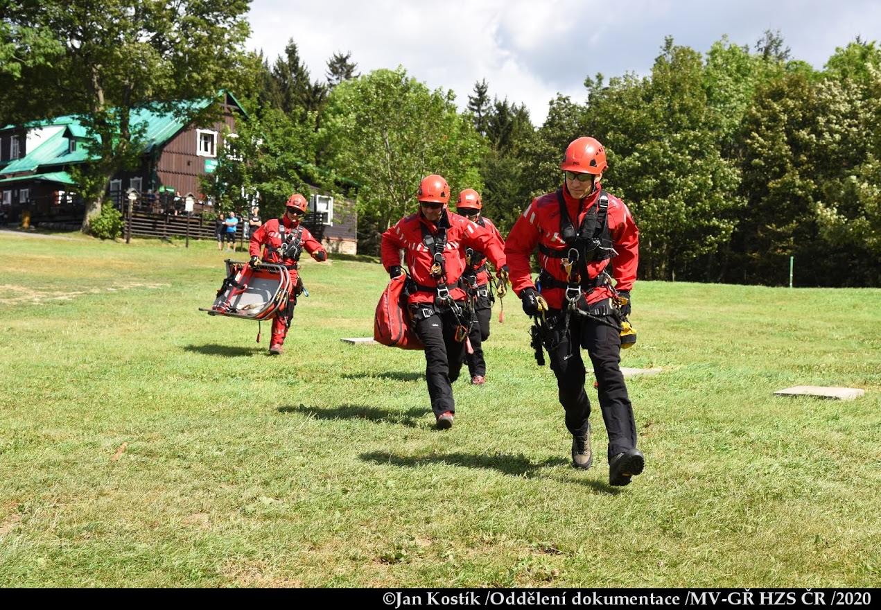 PHA_výcvik leteckých záchranářů_4 záchranáři běží s nosítky po louce.JPG
