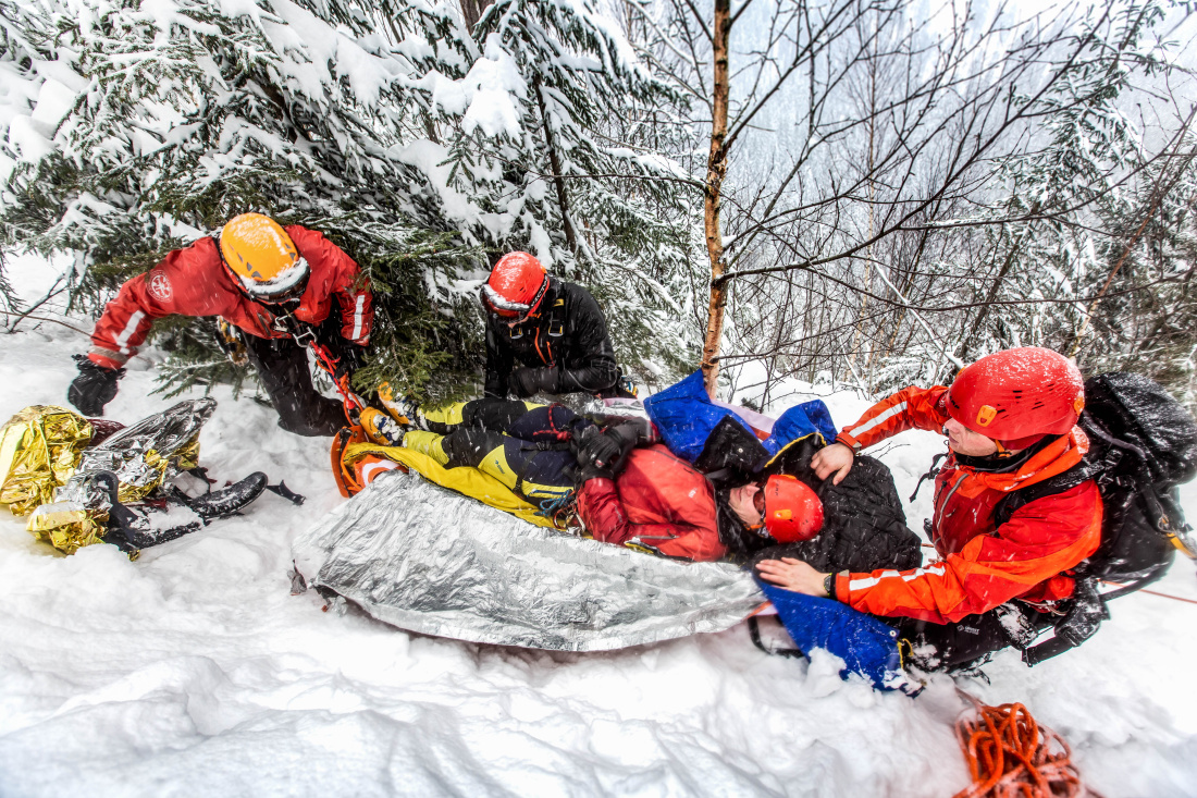 KHK_hasiči lezci při kurzu bezpečného pohybu a záchrany osob v zimním nepřístupném terénu v Krkonoších_3 hasiči ukládají zraněného na nosítka.jpg