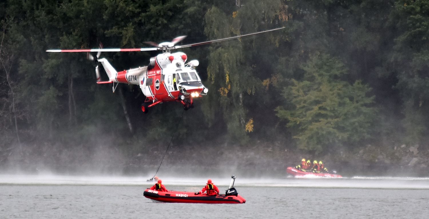 KVK_cvičení IZS - Stoletá voda_z vrtulníku nad vodní hladinou je spuštěno lano k osobám na člunu.jpg