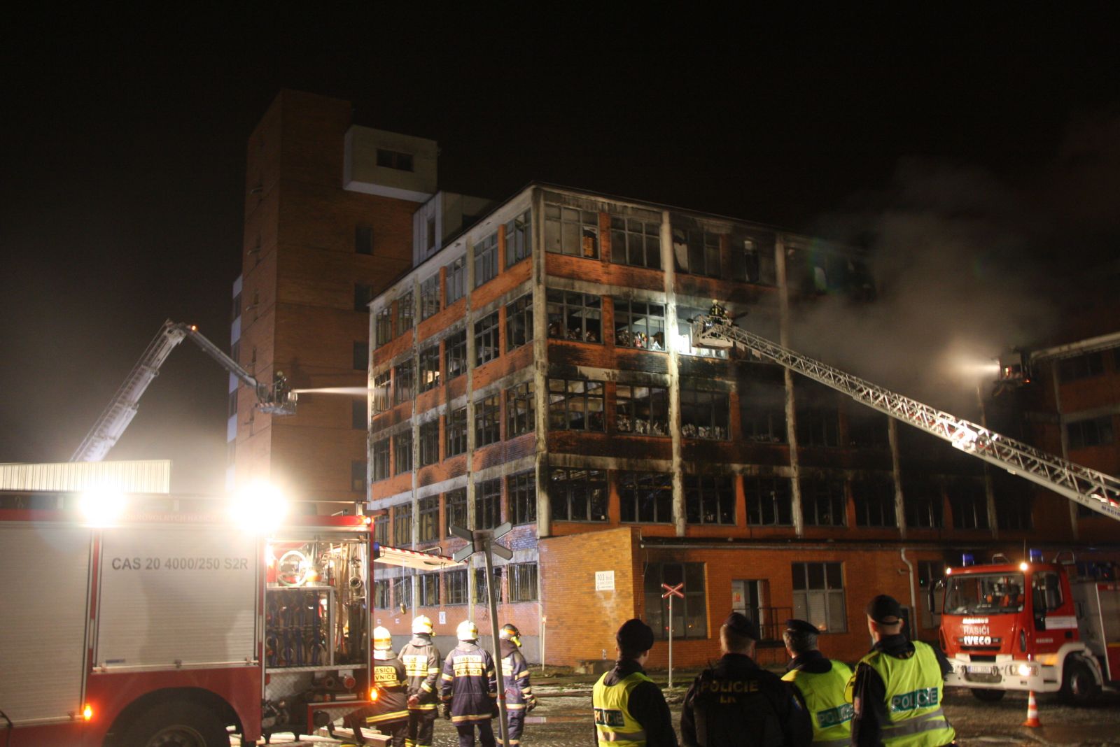 0.6_ZLK_požár Svit Zlín_pohled na hořící budovu a hasiče na plošinách hasící hořící budovu.jpg