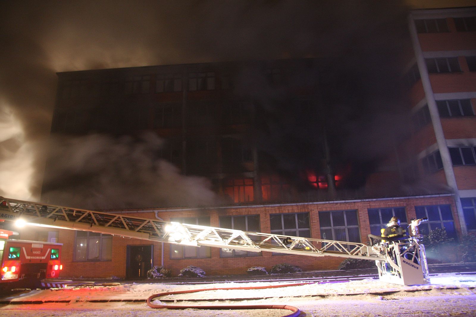 4_ZLK_požár Svit Zlín_pohled na hořící budovu a hasiče na plošině.jpg