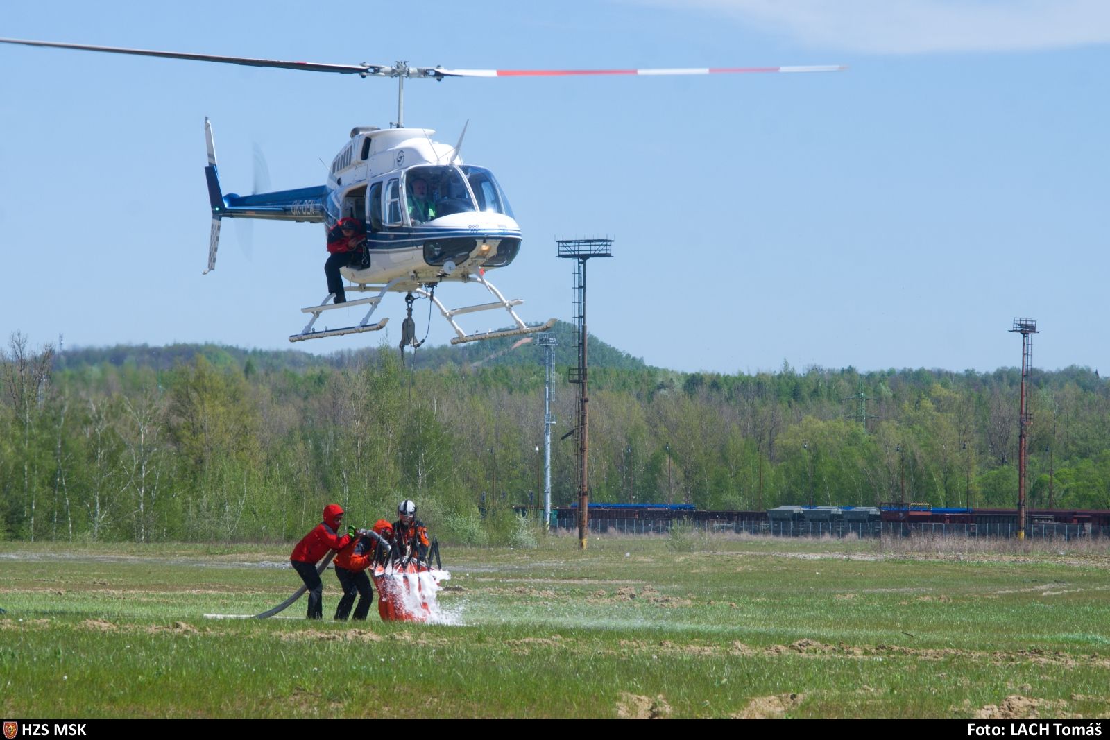 MSK_Požár železného šrotu v Ostravě_pohled na hasiče plnící bambivak u zasahujícího vrtulníku.jpg
